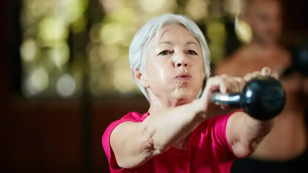 Toning Arms After 60: Empowering Womens Fitness Through Effective Weight Training 1 Older woman doing weight training Rowley Regis to help her strength and longevity