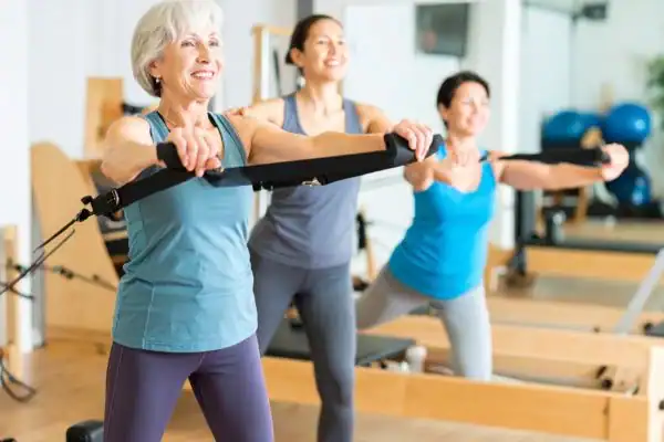 Toning Arms After 60: Empowering Womens Fitness Through Effective Weight Training 2 older woman doing weight training Rowley Regis and resistance in the gym to tone upper arms